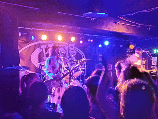 image of a band on stage with blueish purple lighting