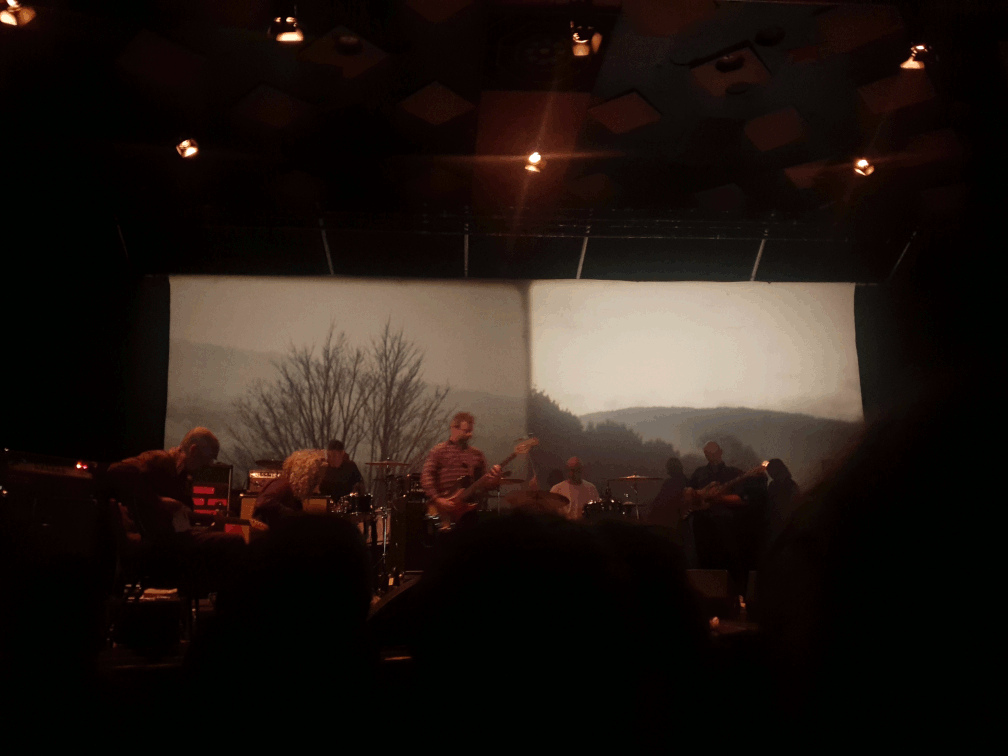 godspeed you! black emporer on stage at barrowland, black and white photos of scenery are projected on the wall behind