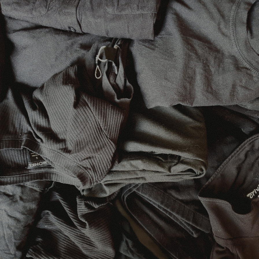 photo of black clothes in a pile on a bed