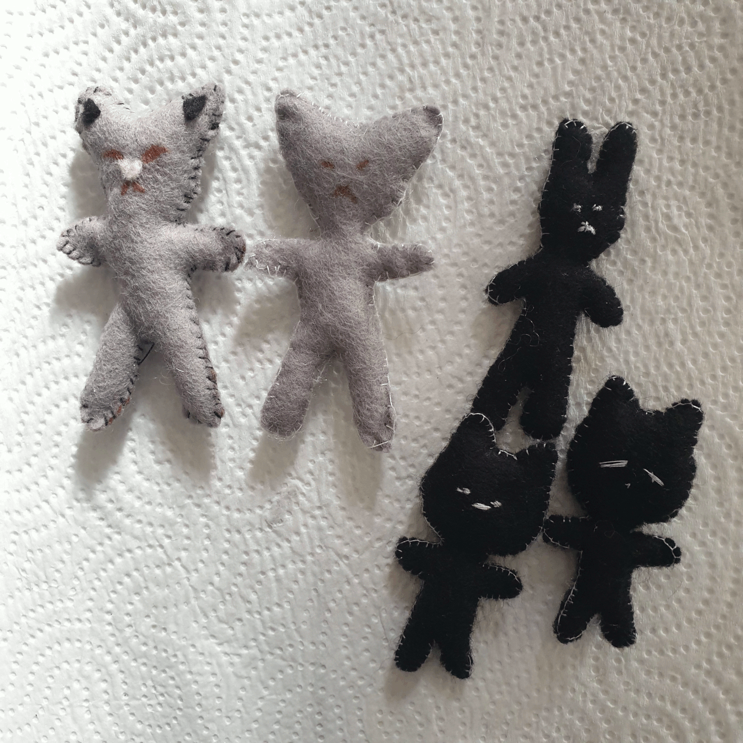 2 felt grey cats with black stitching; one black bunny with white stitching; 2 black cats with white stitching