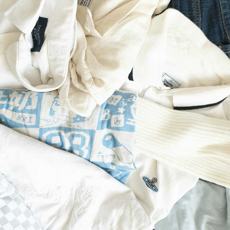 photo of a smaller amount of white and light blue clothes in a pile on a bed